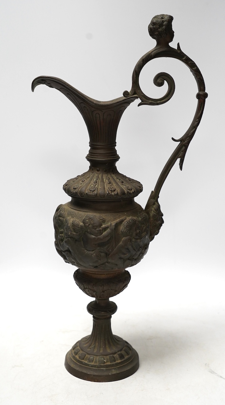 A Cellini style bronze ewer, possibly converted to a lamp later, decorated with putti panel and head handle, 42cm high. Condition - fair to good